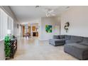 Open-concept living room featuring tile floors, neutral walls, and a comfortable gray sectional sofa at 10334 E Diamond Ave, Mesa, AZ 85208
