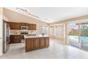 Bright kitchen features stainless appliances, a center island, and a view of the backyard pool at 10845 W Quail Ave, Peoria, AZ 85373
