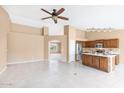 Open-concept living area features tile floors, a ceiling fan, and a kitchen with a center island at 10845 W Quail Ave, Peoria, AZ 85373