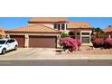 Charming home featuring a tile roof, two-car garage, and beautiful bougainvillea at 14021 N 29Th St, Phoenix, AZ 85032