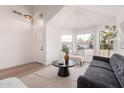 Bright living room featuring a modern sofa, neutral chairs, a dark wood table, and large windows at 1627 W Maplewood St, Chandler, AZ 85286