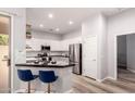 Bright kitchen features stainless appliances, granite counters, a breakfast bar, and white cabinetry at 1925 W Olive Way, Chandler, AZ 85248