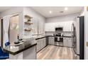 Modern kitchen with stainless steel appliances, sleek granite countertops, and stylish floating shelves at 1925 W Olive Way, Chandler, AZ 85248