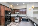 Well-equipped kitchen featuring black appliances, dark wood cabinets, and ample counter space at 20750 N 87 St # 2103, Scottsdale, AZ 85255