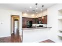 Bright kitchen with wooden floors, black appliances, and an open counter to the living area at 20750 N 87 St # 2103, Scottsdale, AZ 85255