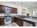Modern kitchen with stainless steel appliances, dark wood cabinetry, and gray countertops at 20750 N 87 St # 2103, Scottsdale, AZ 85255
