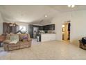 Open floor plan living room with tile floors, a sofa, dark cabinets, and a view of the bathroom at 22222 W Lower Buckeye Rd, Buckeye, AZ 85326