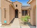 Welcoming front entrance with detailed door, desert landscaping, and solar panels above the front window at 2422 W Maya Way, Phoenix, AZ 85085