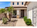 Inviting front entrance with covered porch, desert landscaping, and a solid wood door at 2460 E Crescent Way, Gilbert, AZ 85298
