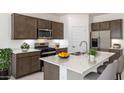 Modern kitchen featuring stainless steel appliances, a spacious island, and contemporary cabinetry at 25096 N 154Th Ln, Surprise, AZ 85387