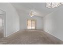 Spacious living room featuring neutral carpet, ceiling fan, sliding glass door and vaulted ceiling at 330 S Valley Dr, Apache Junction, AZ 85120