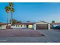 Charming single-story home with a two-car garage, desert landscaping and blue skies at 4031 W Palmaire Dr, Phoenix, AZ 85051