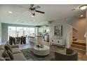 Open-concept living room with modern furnishings, staircase, and tile floors flowing into the kitchen and dining areas at 4242 E Erie St, Gilbert, AZ 85295