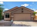 Tan stucco single story home featuring a wide driveway and an attached two-car garage at 42758 W Camino De Janos --, Maricopa, AZ 85138