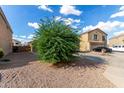 Two-story house with desert landscaping, two car garage and driveway under a beautiful cloudy blue sky at 42758 W Camino De Janos --, Maricopa, AZ 85138