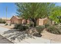 Attractive single-story home with mature landscaping, desert plants, and a three-car garage at 4401 E Barwick Dr, Cave Creek, AZ 85331