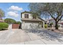 A beautiful two-story home with an attached garage and spacious driveway, set against a backdrop of lush greenery at 4554 E Coyote Wash Dr, Cave Creek, AZ 85331