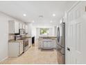 Well-lit kitchen features modern appliances and a neutral color palette and tile flooring at 4808 E Betty Elyse Ln, Scottsdale, AZ 85254