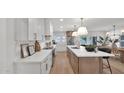 Modern kitchen with white cabinets, quartz countertops, stainless appliances, and island with pendant lighting at 5109 E Blanche Dr, Scottsdale, AZ 85254