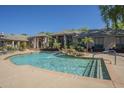 Community pool featuring waterfall features, lounge chairs, and a well-maintained surrounding landscape at 5345 E Van Buren St # 305, Phoenix, AZ 85008