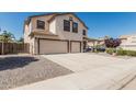 View of the front of the house, showcasing the large driveway and desert landscaping at 551 E Sun Valley Farms Ln, San Tan Valley, AZ 85140