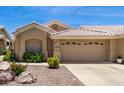 Close-up view of charming single-story home featuring a desert landscape and an attached two-car garage at 5830 E Mckellips Rd # 120, Mesa, AZ 85215
