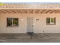 Close up of the front of the house including the front door and two windows with security bars at 649 S Temple St, Mesa, AZ 85204
