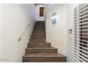 Contemporary staircase with wood treads, a metal handrail, and a modern sconce at 7222 E Gainey Ranch Rd # 241, Scottsdale, AZ 85258