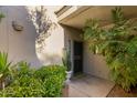 Charming home entrance featuring a covered porch, lush greenery, and a secure gate for added privacy at 7710 E Gainey Ranch Rd # 142, Scottsdale, AZ 85258