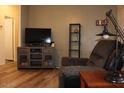 Relaxing living room features wood-look floors, a media center and a recliner for comfortable lounging at 7807 E Main St # G-23, Mesa, AZ 85207