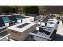 Relaxing outdoor seating area with a stone fire pit, ideal for entertaining and enjoying cozy evenings at 7940 E Quill Ln, Scottsdale, AZ 85255