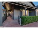 Inviting covered front porch features a brick walkway, potted plants, and charming statue, leading to the front door at 8037 E Krail St, Scottsdale, AZ 85250