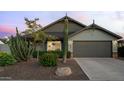 Charming home with desert landscaping, including a tall saguaro cactus and manicured bushes near the garage at 8037 E Krail St, Scottsdale, AZ 85250