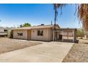 Single-story home with gravel yard, carport and a concrete driveway on a sunny day with a clear blue sky at 8101 E 4Th Ave, Mesa, AZ 85208