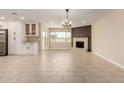 Spacious open-plan living room featuring a brick fireplace, tiled flooring, and a modern kitchen setup at 8124 N 45Th Ave, Glendale, AZ 85302