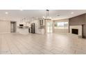 Bright open-concept living space with tile floors, a fireplace, and a modern kitchen in the background at 8124 N 45Th Ave, Glendale, AZ 85302
