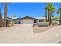 Charming home featuring a spacious driveway, two-car garage, and mature palm trees at 8326 E Valley View Rd, Scottsdale, AZ 85250