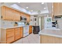 Functional kitchen with light wood cabinets, modern appliances, and ample counter space at 10648 W Loma Blanca Dr, Sun City, AZ 85351