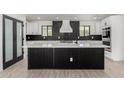 Modern kitchen with a large island, black accents, and stainless steel appliances at 1304 W Ocotillo Rd, Phoenix, AZ 85013