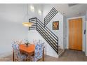 Living room dining area features stairs with metal railing and modern light fixtures at 17 W Vernon Ave # 31, Phoenix, AZ 85003