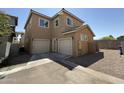 Rear view of two-story tan home with two-car garage and neutral colored trim at 1725 W Pollack St, Phoenix, AZ 85041