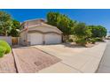 A well-maintained house boasts a three-car garage, desert landscaping, and an American flag at 1802 W Encinas St, Gilbert, AZ 85233