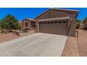 Charming single-story home with a well-maintained desert landscape, patio, and two-car garage at 20211 N Winter Escape Ct, Maricopa, AZ 85138