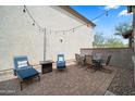 Cozy outdoor patio with comfortable seating, brick pavers, and decorative string lights at 20872 W Thomas Rd, Buckeye, AZ 85396