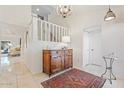 Bright foyer featuring neutral tile floors, wooden console table, staircase, and chandelier at 2313 S Grandview Ave, Tempe, AZ 85282
