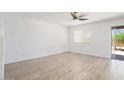 Spacious bedroom with hardwood floors, a ceiling fan, and a sliding glass door at 23772 W Grove St, Buckeye, AZ 85326