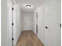 Bright hallway with new hardwood floors, neutral colored walls, and modern lighting at 23772 W Grove St, Buckeye, AZ 85326