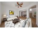 Cozy living room featuring a ceiling fan, a fireplace, and stylish decor at 29270 W Weldon Ave, Buckeye, AZ 85396