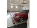 A car in a garage with bare, unpainted walls and multiple overhead lights and doors at 29935 W Roosevelt St, Buckeye, AZ 85396