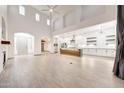 Open-concept living room with high ceilings, tile floors, and a modern kitchen at 3467 N Hooper St, Buckeye, AZ 85396